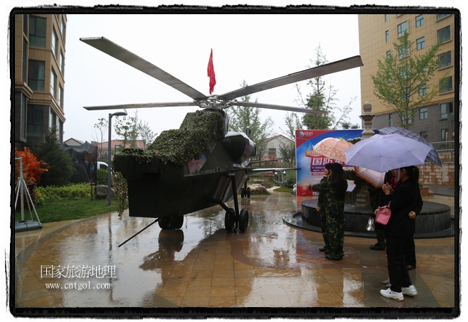 小區(qū)突然出現(xiàn)“飛機坦克”，其中殲15艦載戰(zhàn)斗機一架、99式主戰(zhàn)坦克一輛、武直-10武裝直升機一架，吸引了眾多市民雨中圍觀、合影。