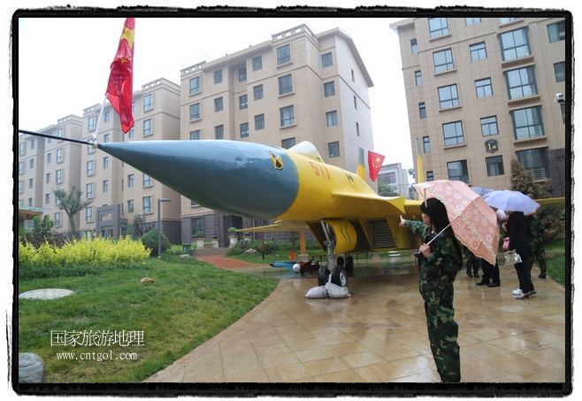 小區(qū)突然出現(xiàn)“飛機坦克”，其中殲15艦載戰(zhàn)斗機一架、99式主戰(zhàn)坦克一輛、武直-10武裝直升機一架，吸引了眾多市民雨中圍觀、合影。